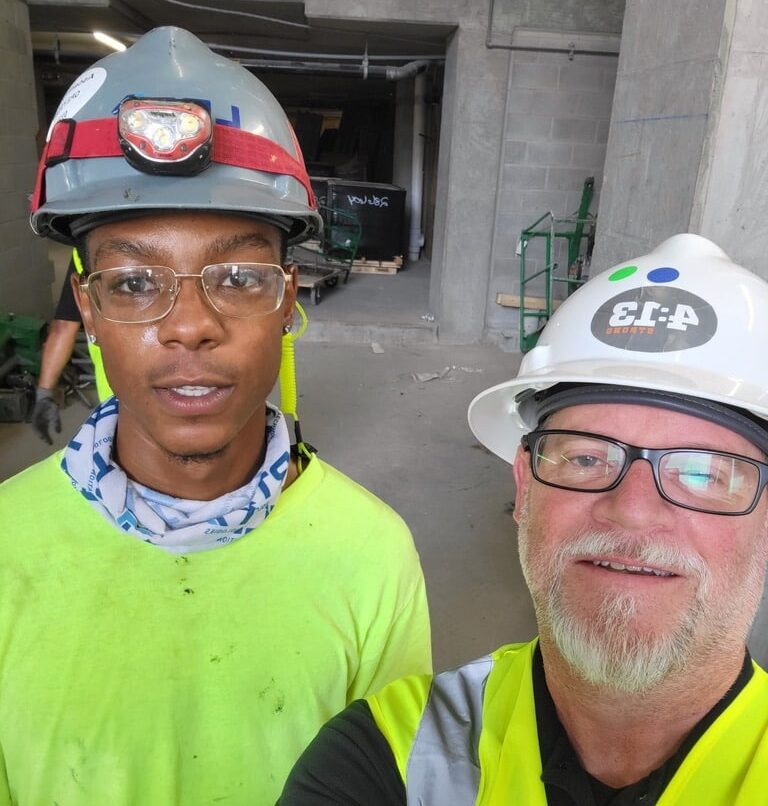 Selfie of two men in hard hats and vets